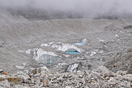 3 little pools that will grow larger over time that have formed due to melting ice at the alpine area along the trail to Everest Base Camp, Nepal